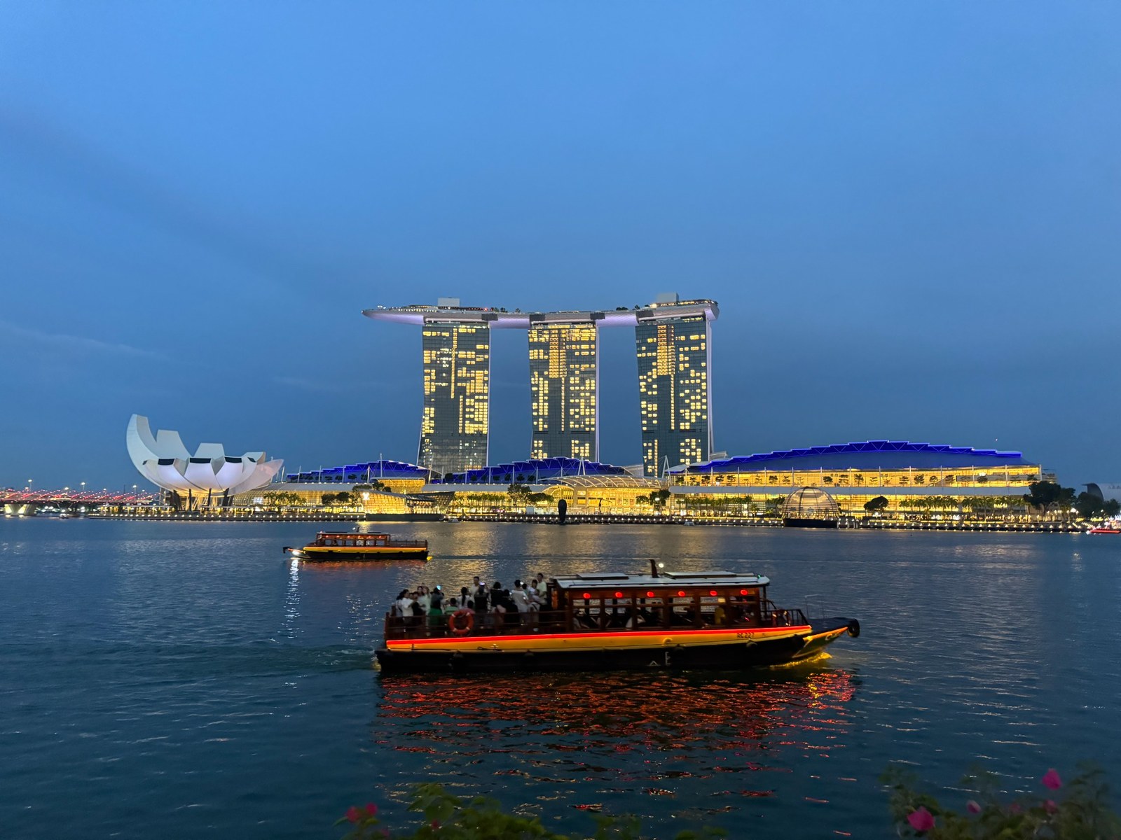 Marina Bay Sands at dusk with a traditional river boat